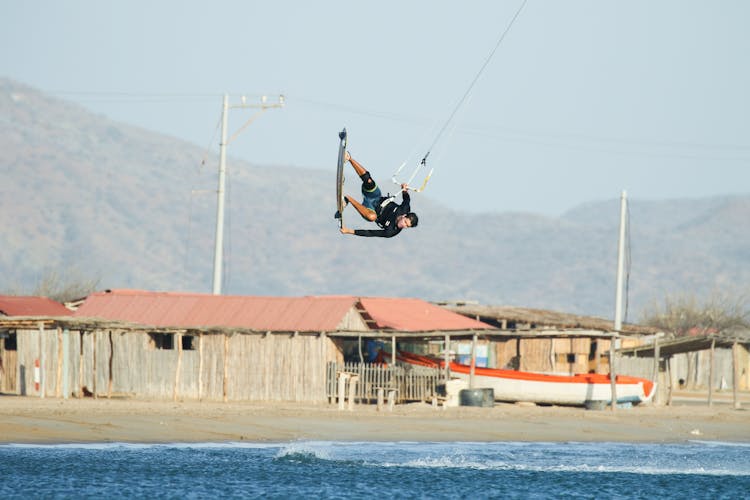 A Man Paragliding In The Beach