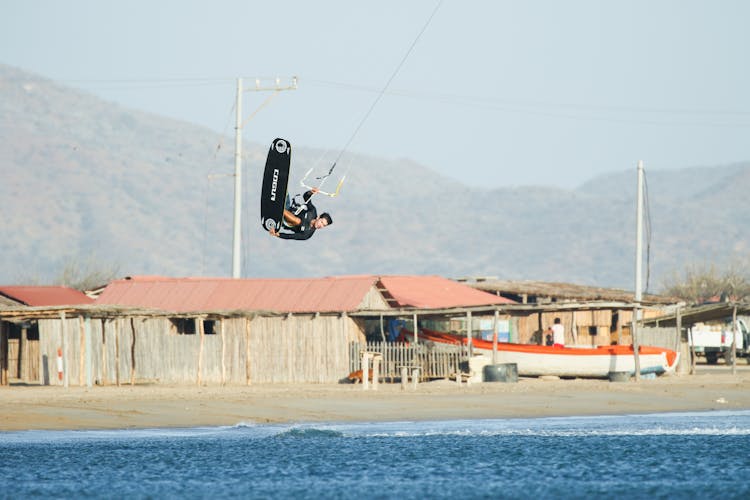 A Man Paragliding In The Beach