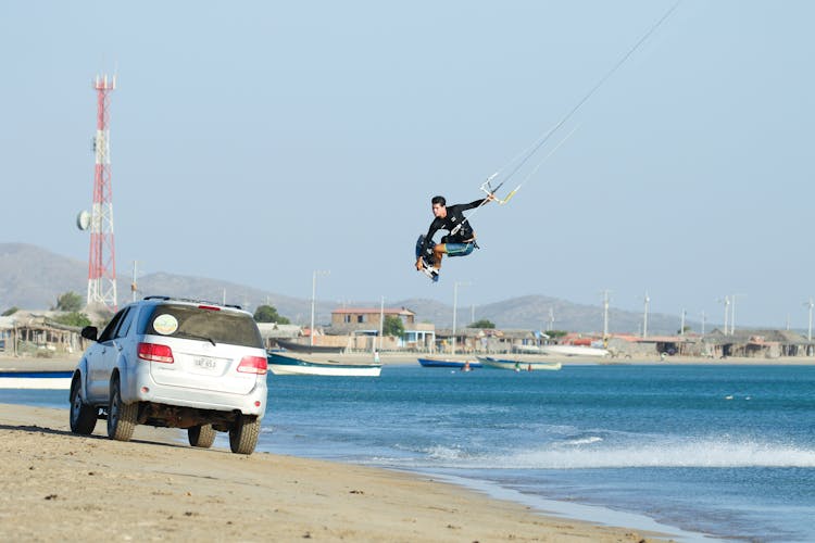 A Man Paragliding In The Beach