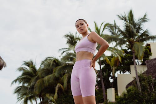 Woman in Sports Clothing Standing in front of Palm Trees