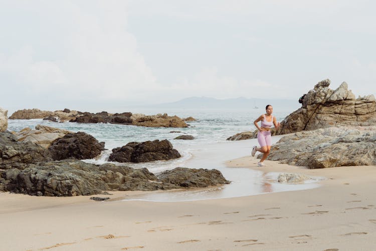 Woman Running On Beach By Sea