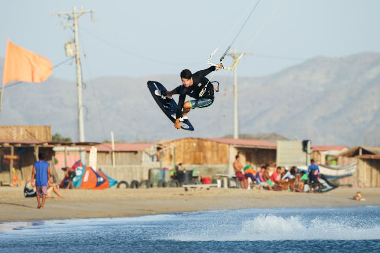 A Man Paragliding In The Beach