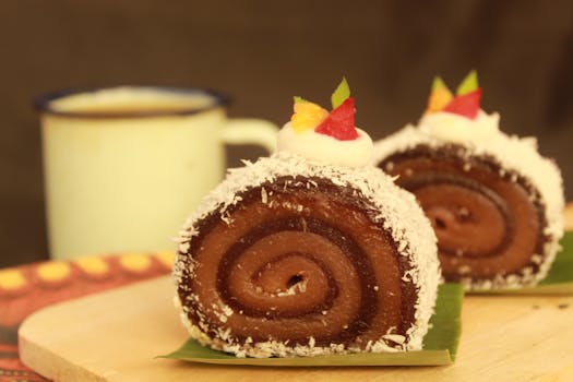 Close-up of a creamy chocolate Swiss roll topped with cream and fruit. Perfect for dessert lovers.
