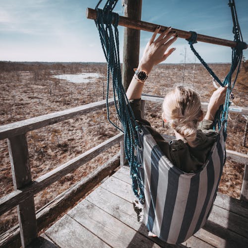 Woman With Blonde Hair On Blue And White Striped Hammock