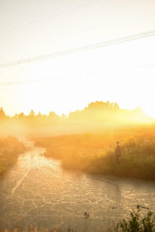 A Person Standing Near River during Sunset