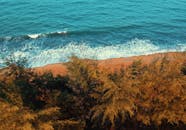 从空中俯瞰，马来西亚登加楼楚凯的海滩与海浪，在郁郁葱葱的树木环绕下，景色令人惊叹