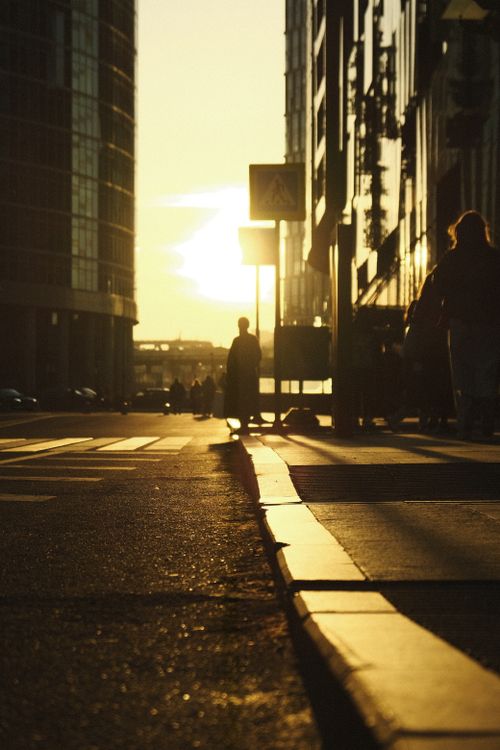 Free Urban street in Moscow at sunset with silhouettes of pedestrians and city buildings. Stock Photo