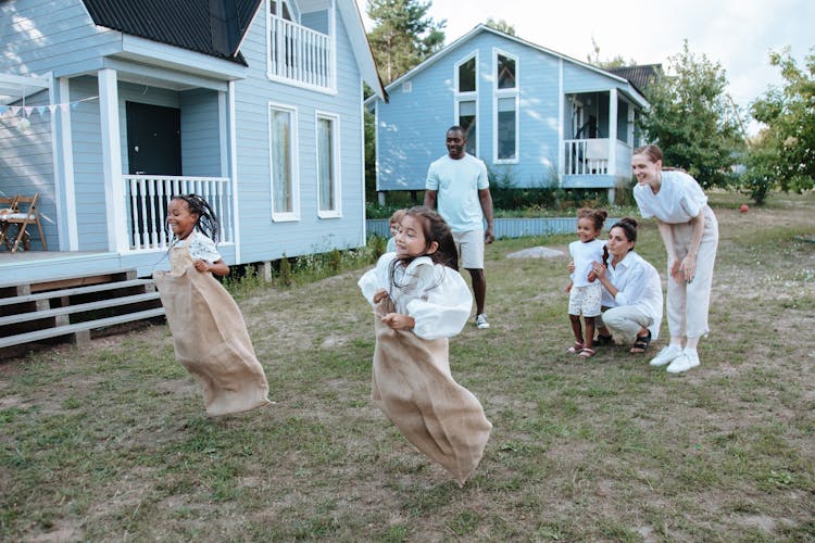 Girl In White Long Sleeve Jumping With Brown Sack