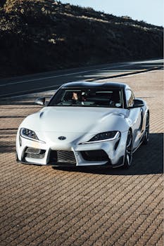 Luxury white sports car parked on a sunny road in Franschhoek, South Africa.