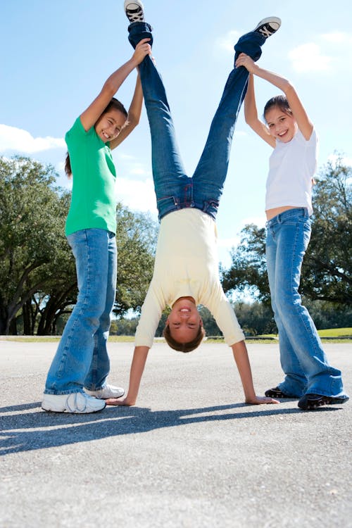 Kids Helping a Friend Doing a Handstand