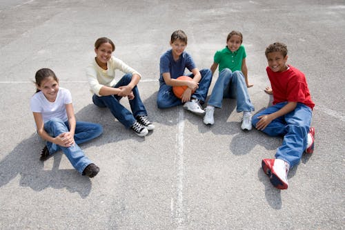 A Group of Teens Sitting on a Concrete Floor