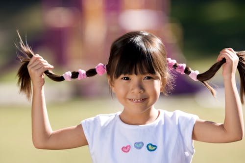 Selective Focus of a Little Girl Holding Her Hair
