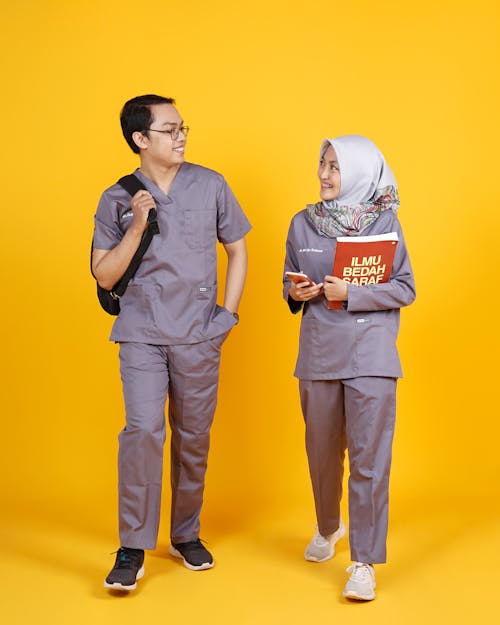 Man in Gray Polo Shirt and Pants Standing Beside Man in Gray Polo Shirt