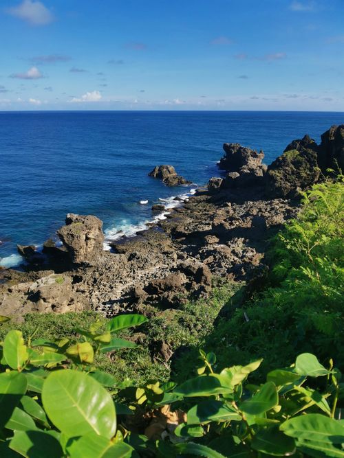 Free Breathtaking view of a rocky coastline meeting the vibrant ocean under a clear sky. Stock Photo