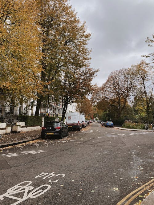 A Road in a City with Parked Cars