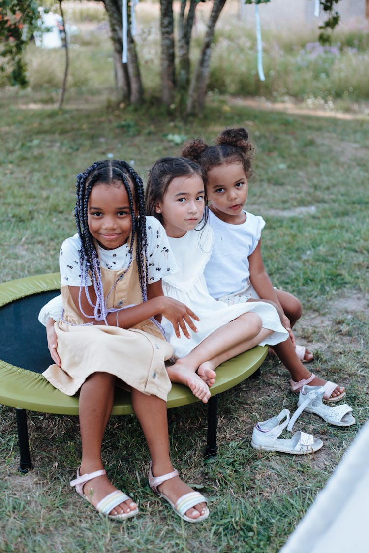 Little Girls Sitting On A Trampoline