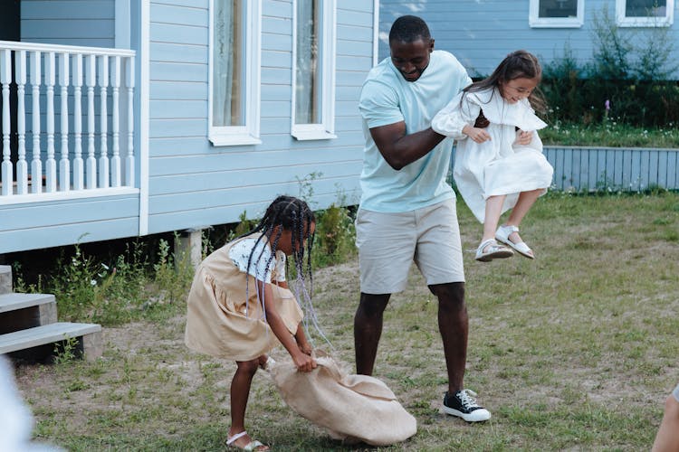 Man Playing With Kids In The Backyard