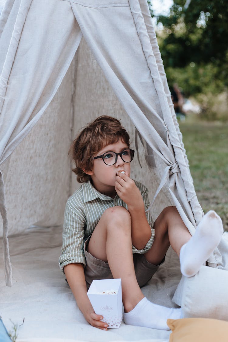 Boy Eating Popcorn In Teepee