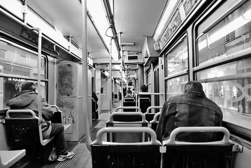 Free Monochrome view of passengers sitting inside a public train in a city. Stock Photo