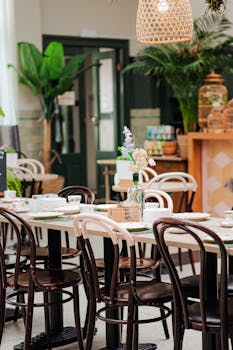 Chic restaurant interior with stylish chairs, lush plants, and a welcoming atmosphere.