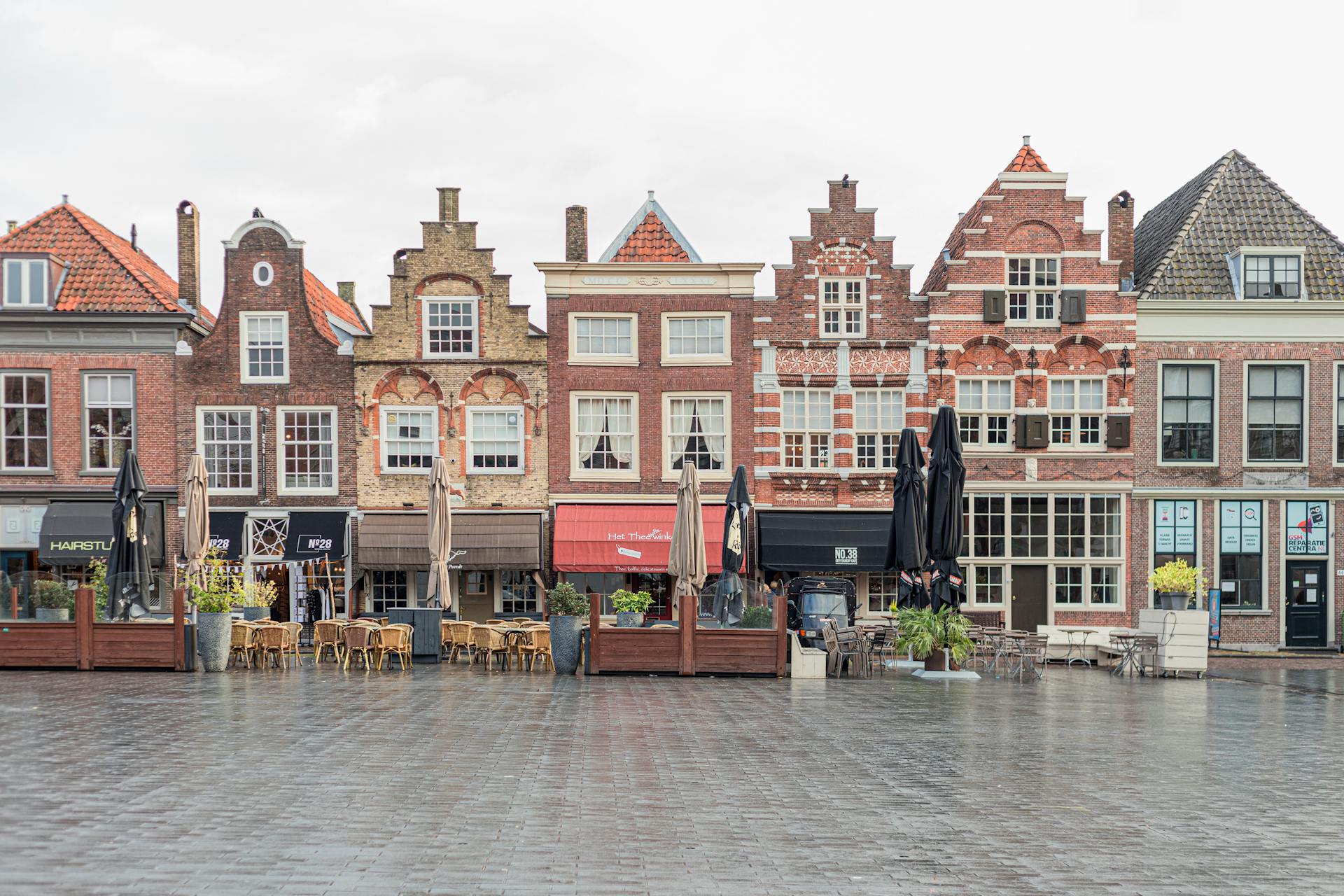 Picturesque European street featuring traditional Dutch gabled buildings and open air cafes.