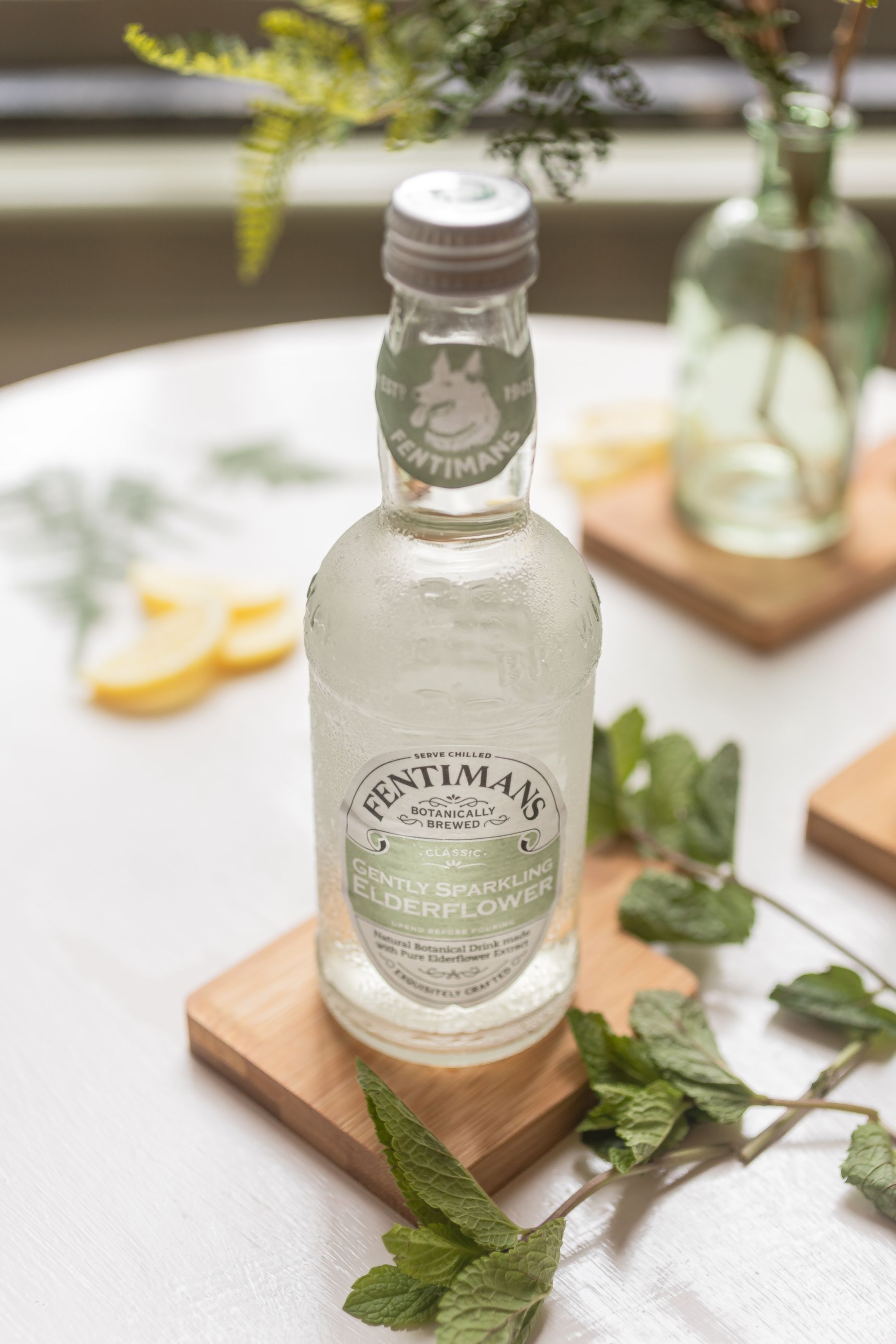 Botanical elderflower drink surrounded by fresh botanicals Botanical elderflower drink surrounded by fresh botanicals