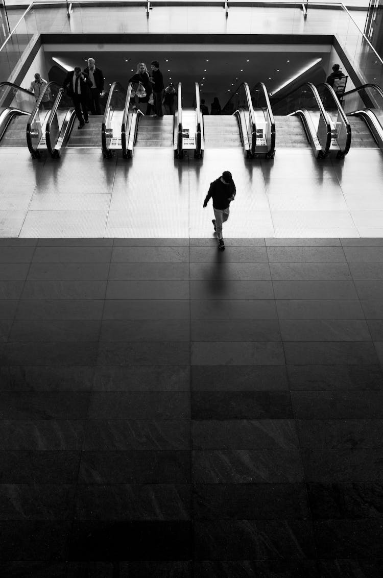 Person Walking Near Escalators