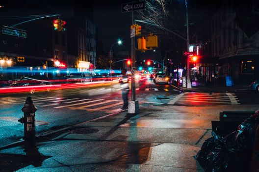 Dynamic night street scene with long exposure highlighting urban lights and city life.