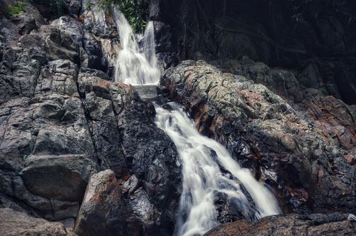 Free A peaceful waterfall cascading over rocky formations in Koh Samui, Thailand, creating a tranquil natural scene. Stock Photo