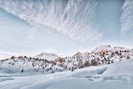 多洛米蒂山脉的雪山景观令人惊叹，其间林木葱郁，云层缭绕