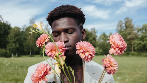 Free Close-Up Shot of a Man in White Suit Holding Pink Flowers Stock Photo