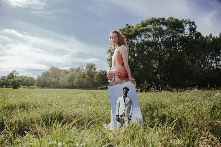 A Woman Holding A Mirror With A Reflection Of A Man In A Suit