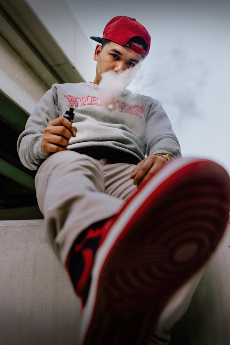 A Man With A Red Cap Vaping