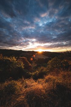 Stunning sunset over a scenic landscape with dramatic clouds and vibrant colors.