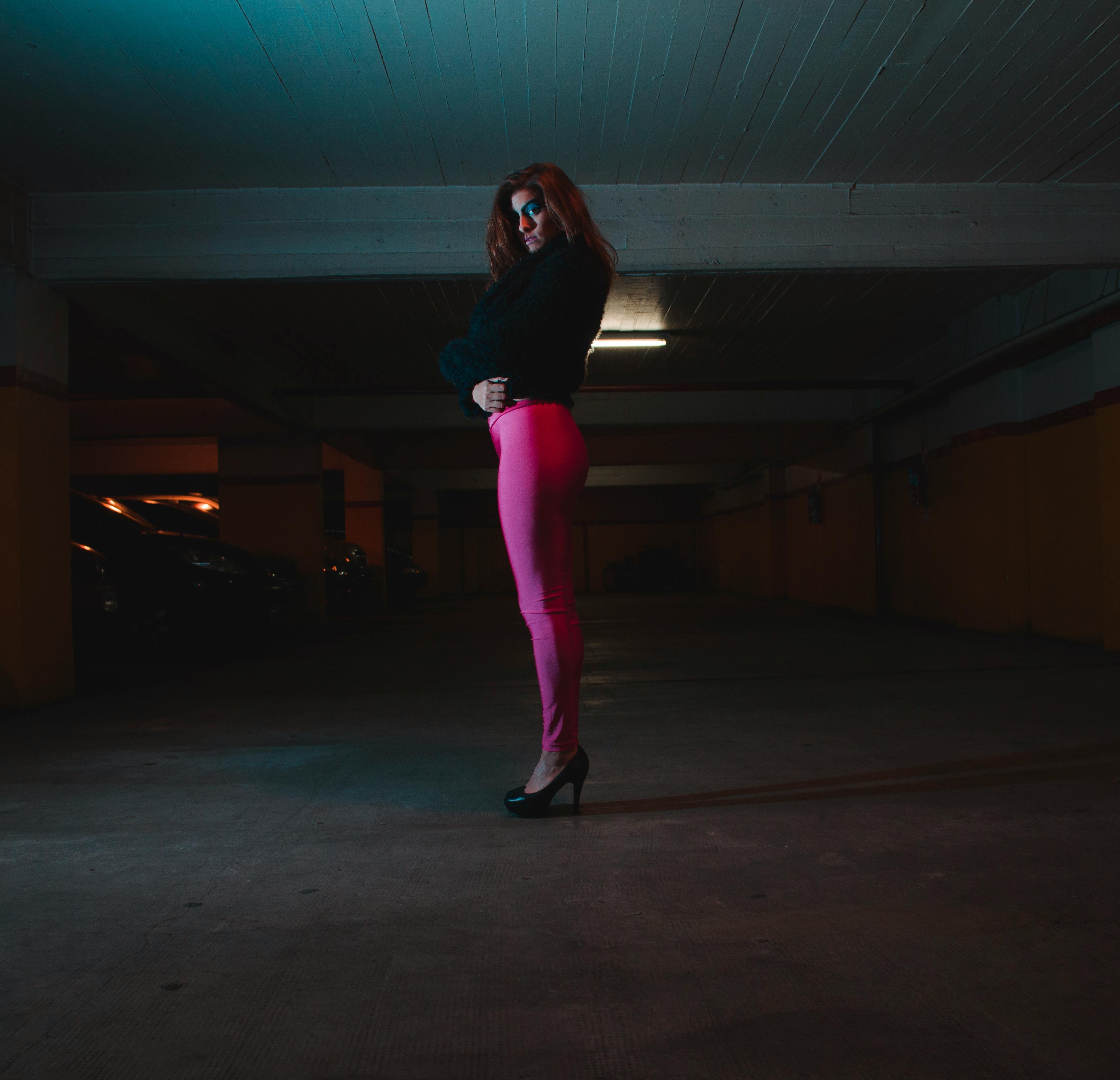 Photo of Woman Wearing Black Shirt and Pink Leggings in Parking Area