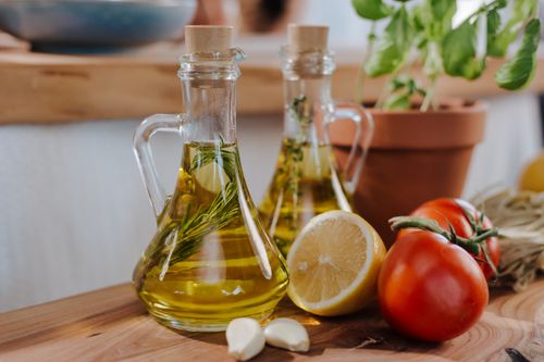Free Close-up of fresh ingredients for Italian cooking featuring olive oil and basil. Stock Photo