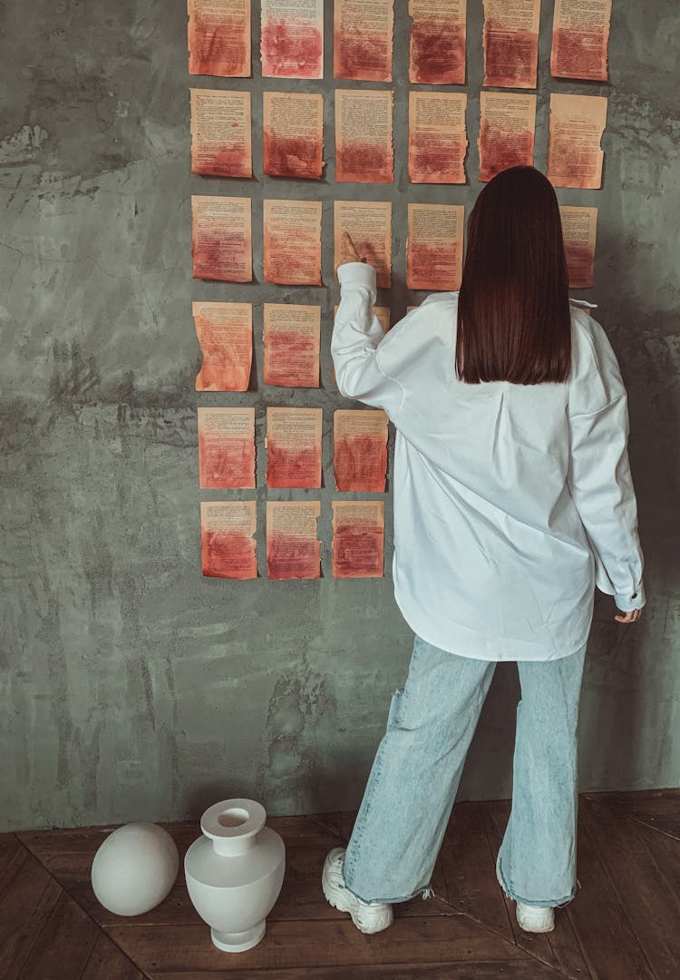 Woman Painting Book Pages Hanged On Wall