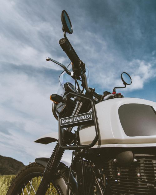 Free A close-up, low angle view of a Royal Enfield motorcycle against a cloudy sky. Stock Photo
