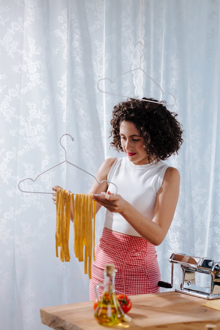 A Female Putting A Freshly Made Pasta On Clothing Hanger 