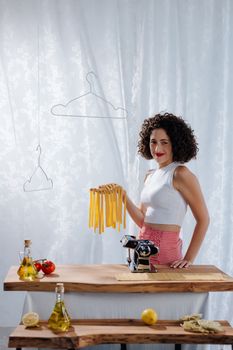 A woman in a home kitchen making fresh pasta, showcasing Italian cuisine with ingredients on a rustic table.