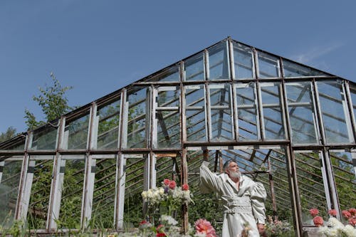 Photo of a Man Posing in an Abandoned Greenhouse