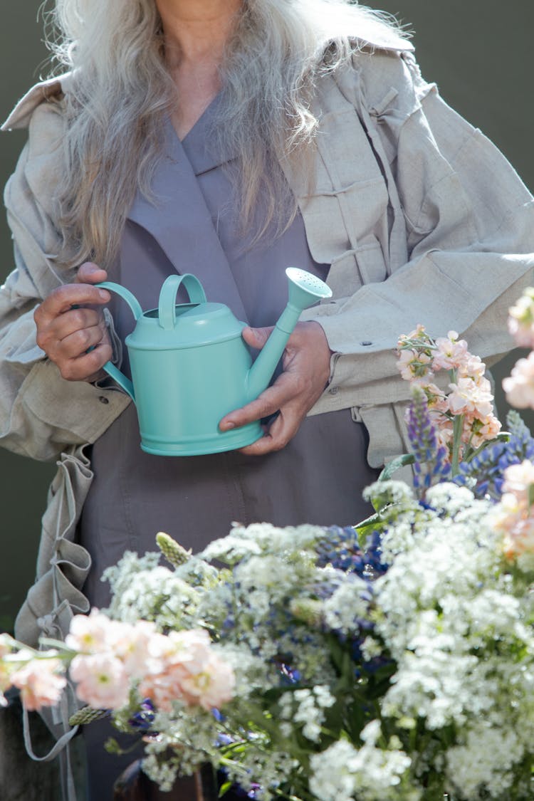 Woman Holding A Watering Can Near Fresh Flowers