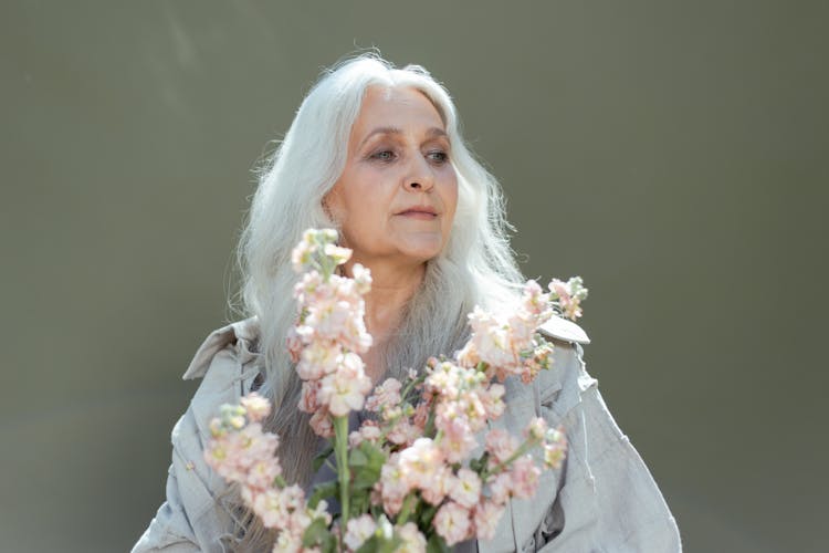 An Elderly Woman Holding Flowers