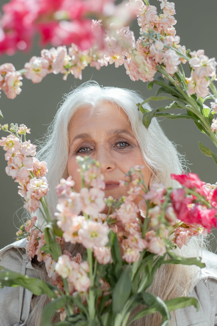 Photo Of An Elderly Woman Near Hoary Stock Flowers
