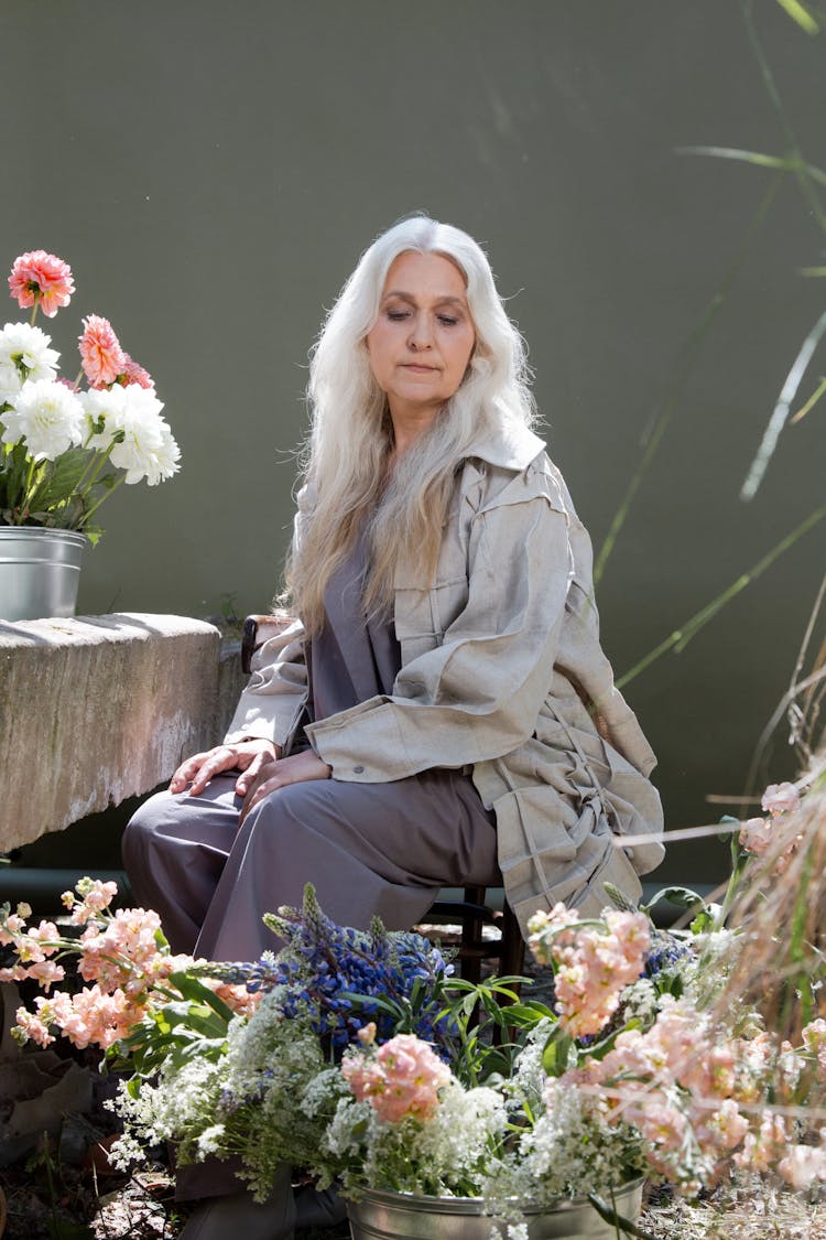 Flowers Around An Elderly Woman Sitting On A Chair