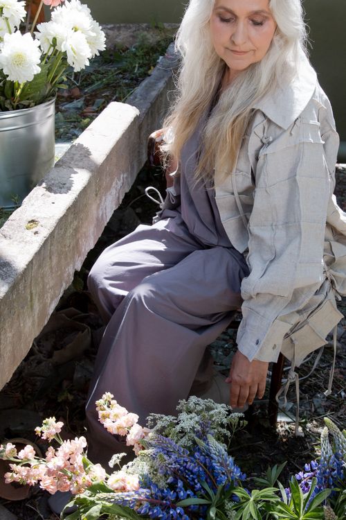 Free Senior woman tending flowers with grace in a greenhouse setting. Stock Photo
