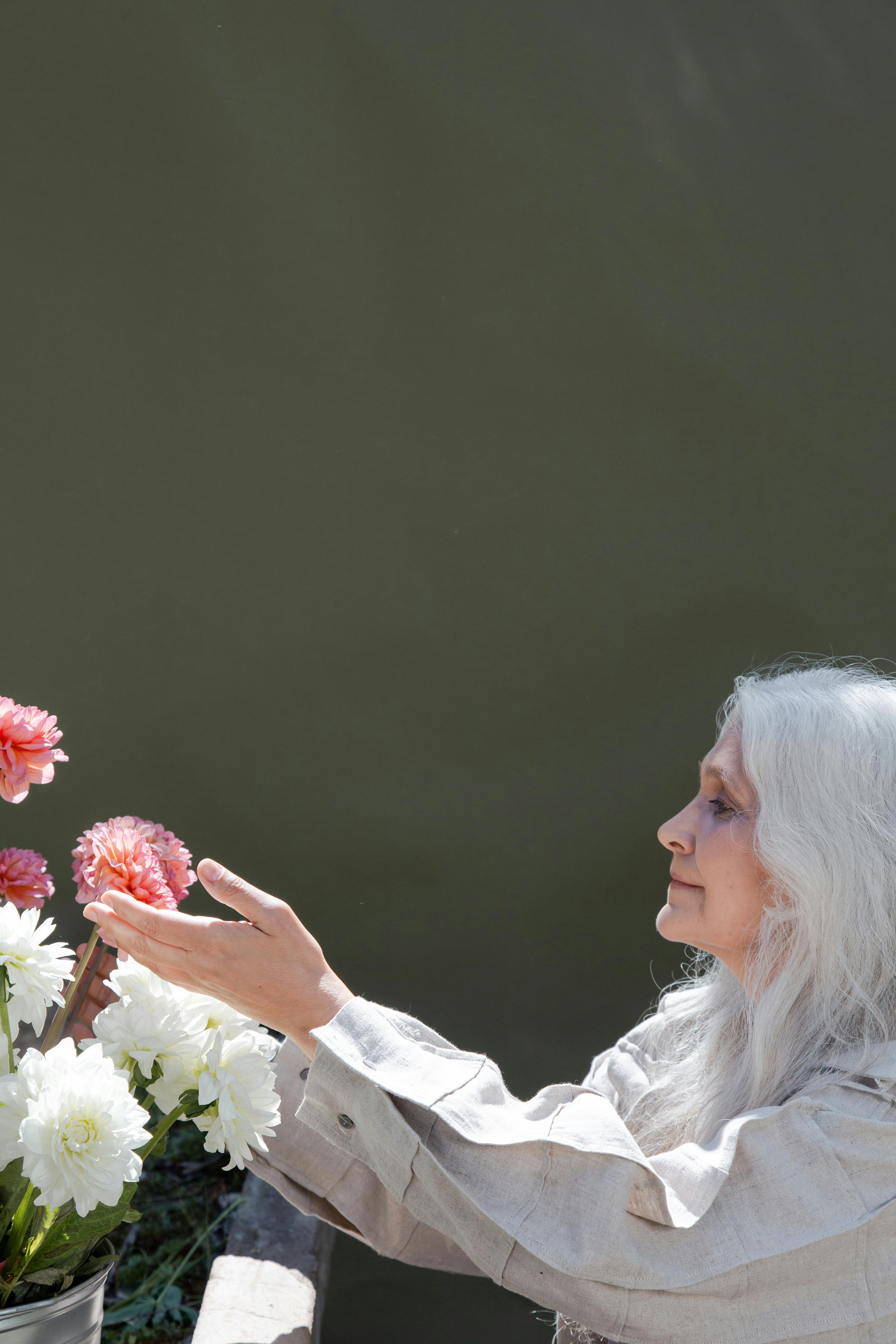 a woman touching pink flowers