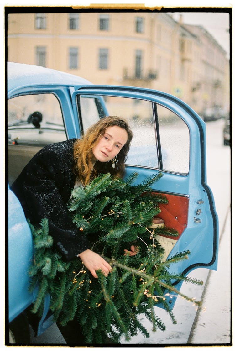 Photograph Of Woman In Car With Christmas Tree