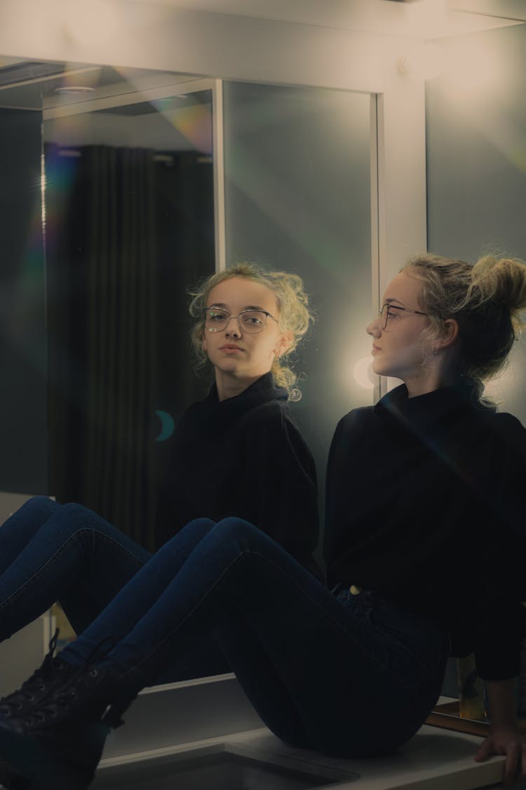 Woman In Black Long Sleeves Sitting On A Dresser Table