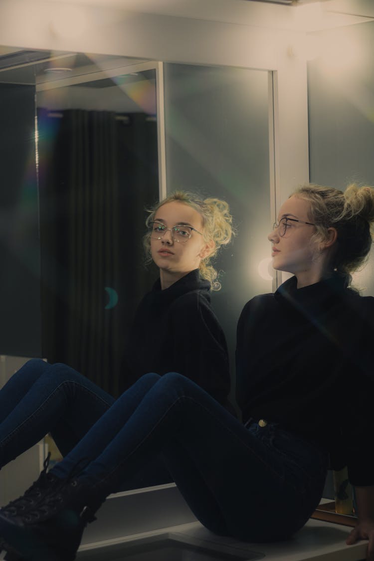 Woman Sitting On Dresser Table Looking At A Mirror